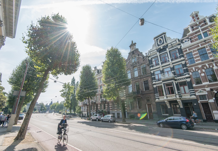 Foto van een Amsterdamse straat met fietser